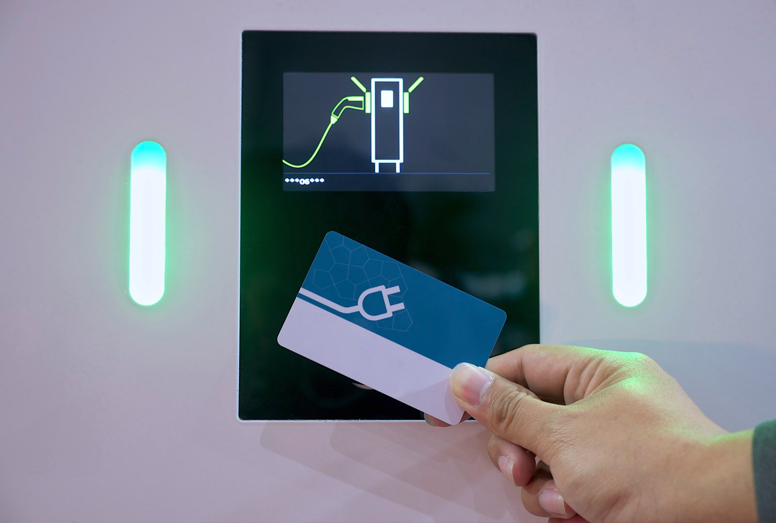 Hand hält eine RFID-Ladekarte mit E-Mobility-Symbol vor ein Display einer Ladesäule – visualisiert Zugang zu Ladeinfrastruktur mit White-Label-Ladekarte