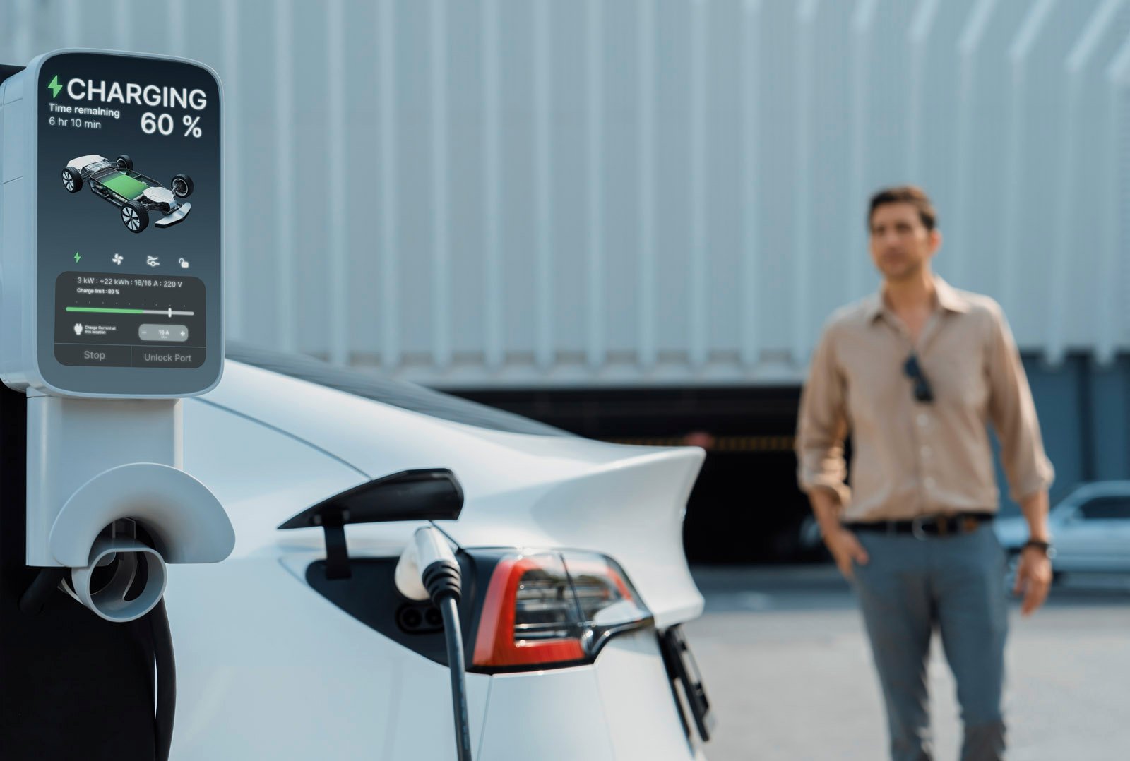 Weißes Elektroauto an DC-Schnellladesäule mit digitaler Anzeige – im Hintergrund steht ein Mann vor einem modernen Gebäude