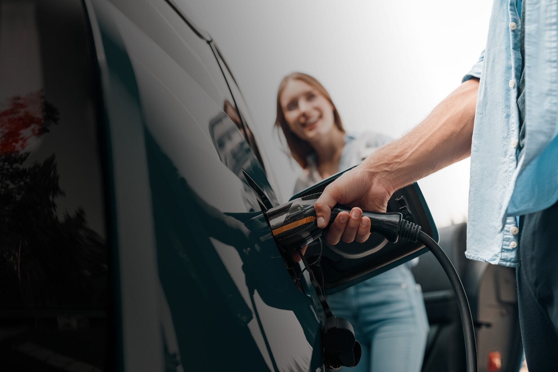 glücklicher Kunde beim Laden des neuen E-Autos